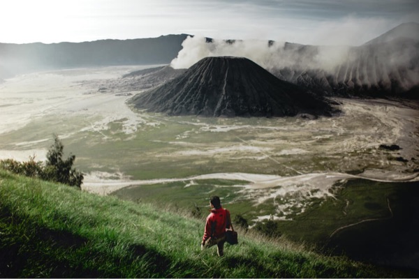 A lone wanderer looking at Mount Bromo volcano in Indonesia.